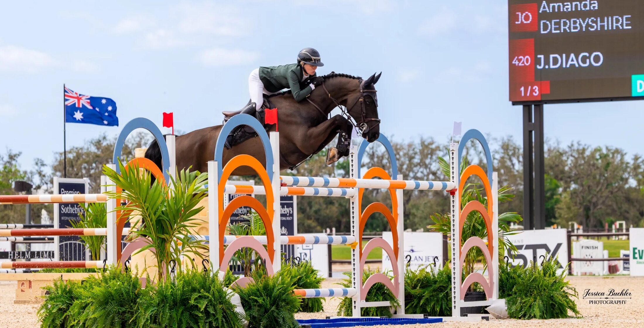 Jumper over a fence with the TerraNova Winter Series scoreboard behind