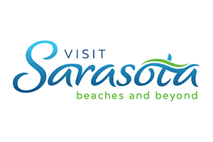 Visit Sarasota logo in blue script with the line beaches and beyond