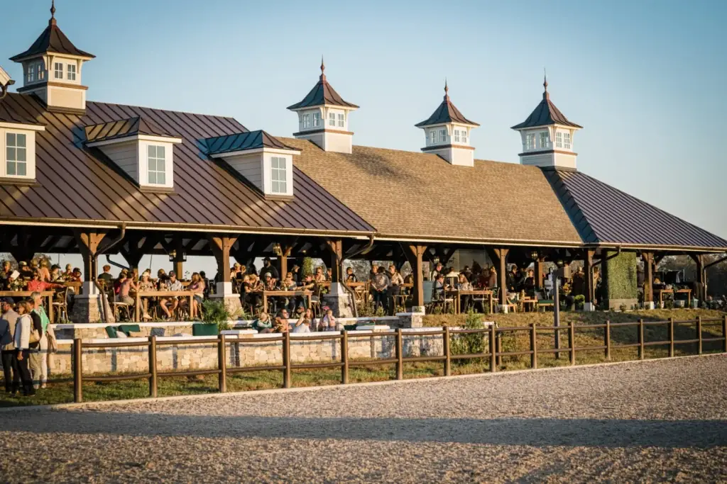 Guests fill the open-sided VIP Pavilion beneath its cupolas in warm evening light