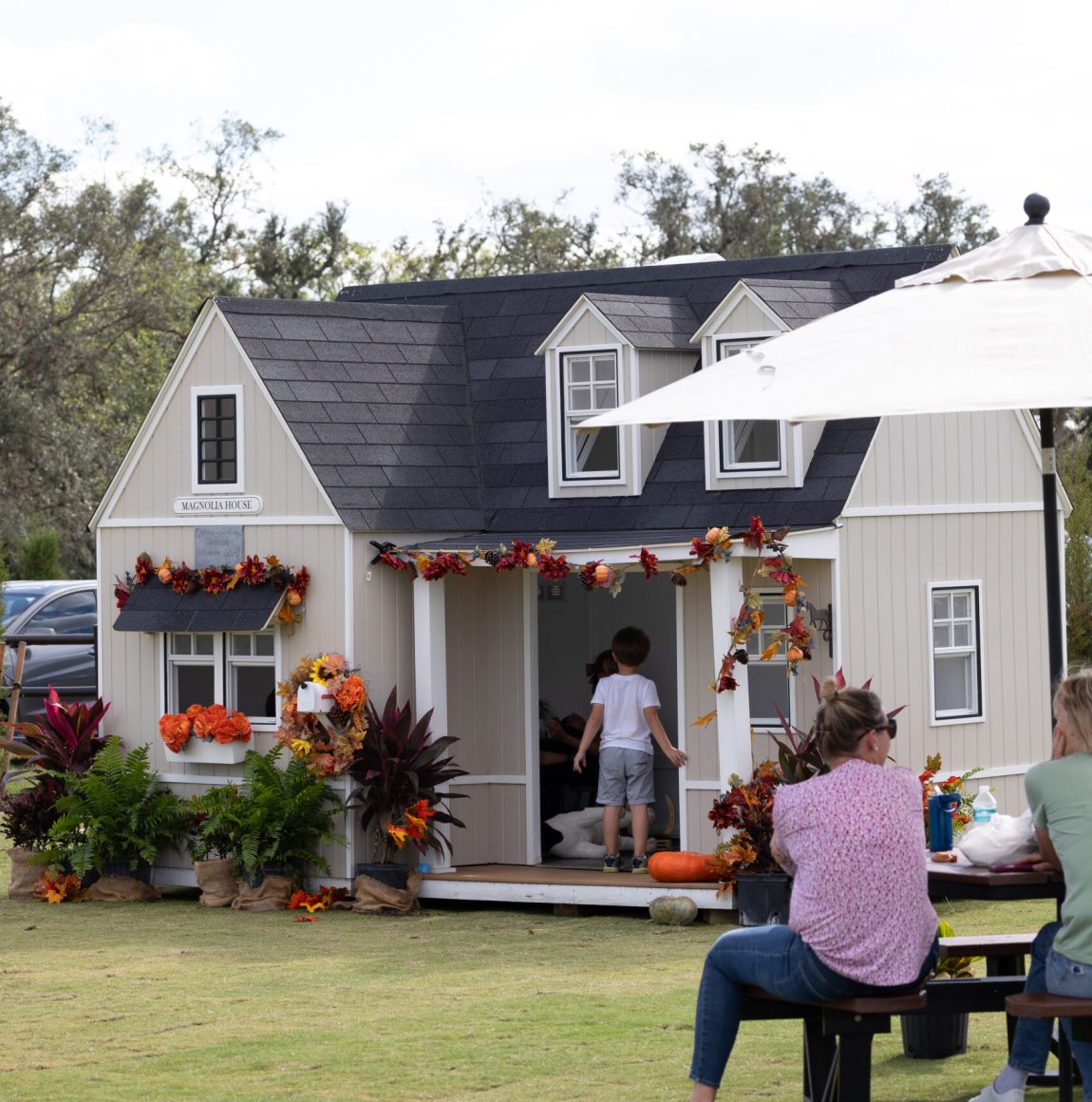 Child plays in a small cottage decorated with autumn garlands and pumpkins